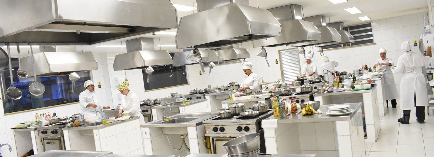 Estudantes de Gastronomia em aula prática em cozinha profissional