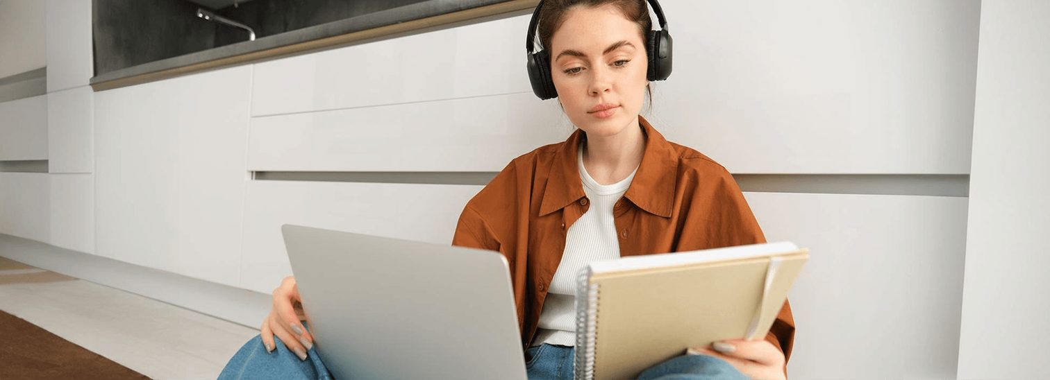 Estudante de fone de ouvido com notebook e caderno