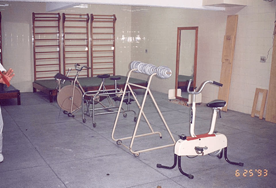 Sala de fisioterapia da CLESAM com barras de parede, macas e bicicleta ergométrica