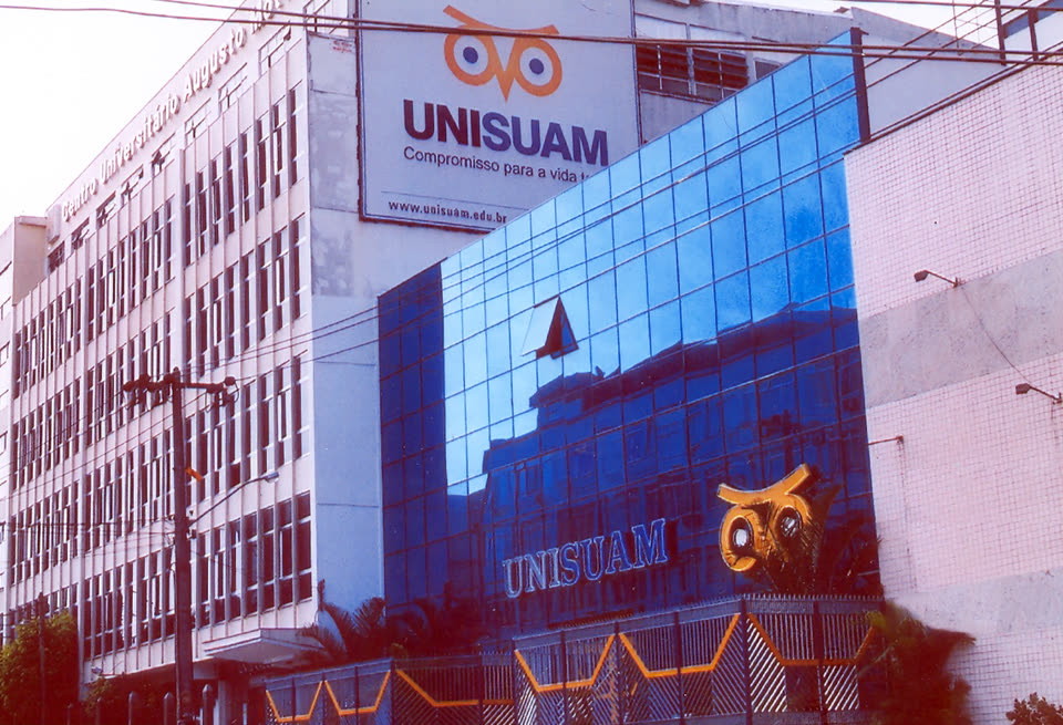 Fachada do Centro Universitário Augusto Motta, com painel da UNISUAM sobre a torre de vidro espelhado