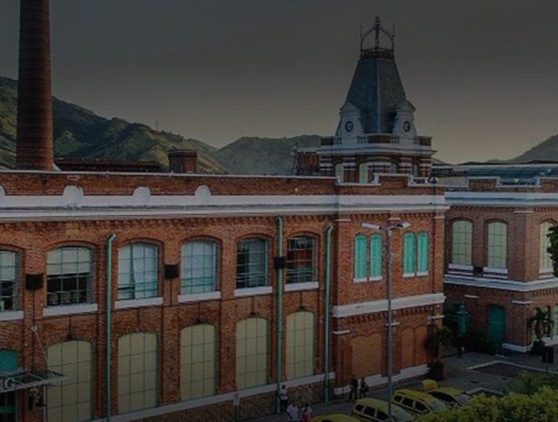 Prédio histórico em tijolo aparente da unidade Bangu, com a torre do relógio