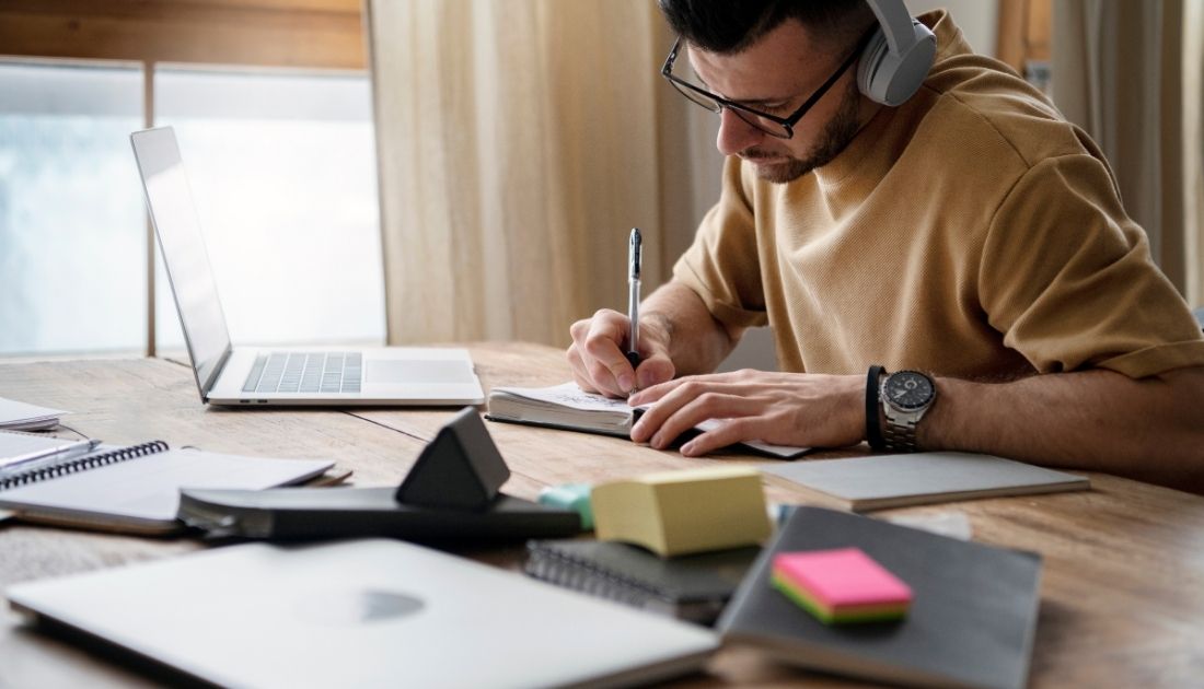 Homem estudando para ENEM ouvindo uma playlist musical