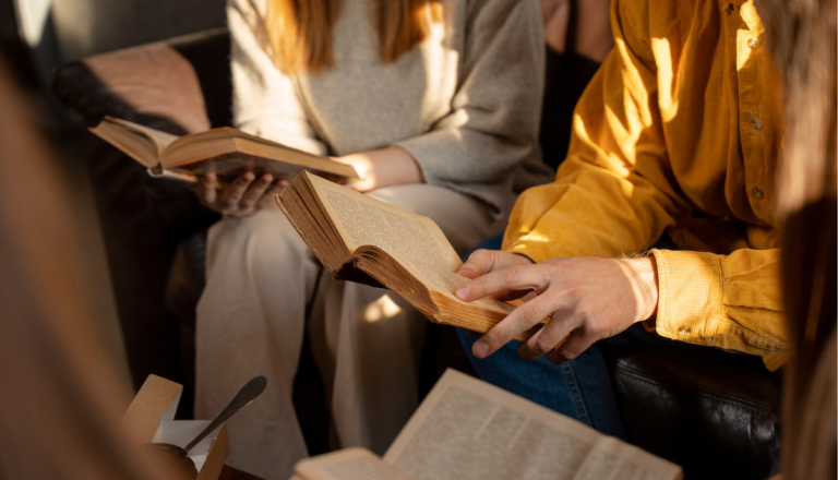 Grupo de pessoas reunidas com livros nas mãos.