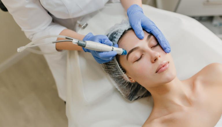 Profissional da área de estética realiza procedimento facial com equipamento estético em paciente deitada em clínica especializada.