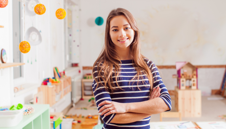 Profissional da educação em uma sala de aprendizagem infantil, ambiente utilizado para atividades pedagógicas e acompanhamento do desenvolvimento de crianças.